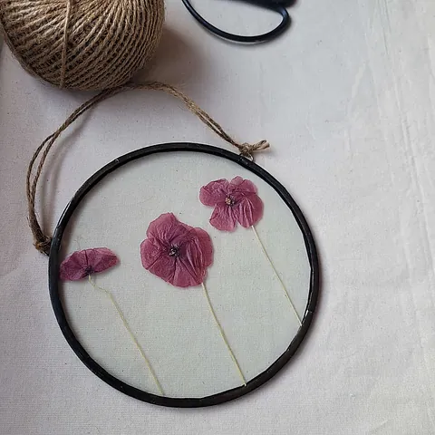 This 6" circular frame includes a trio of real pressed poppies. All our frames are handmade using the Tiffany stained glass technique and a lead free solder. This frame has been stained with a black patina. On purchase your pressed flower frame will be beautifully wrapped and packaged to ensure it reaches you safely. Efforts have been made to use eco friendly packaging wherever possible. Trio of Poppies Real Pressed Poppy Flower Floating Frame